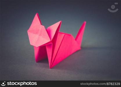 Pink paper cat origami isolated on a blank grey background.. Pink paper cat origami isolated on a grey background