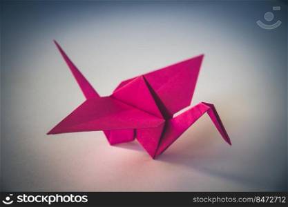 Pink paper crane origami isolated on a blank background.. Pink paper crane origami isolated on blank background