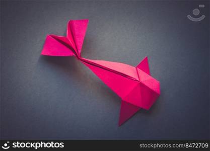 Pink paper fish origami isolated on a blank grey background. Pink paper fish origami isolated on a grey background