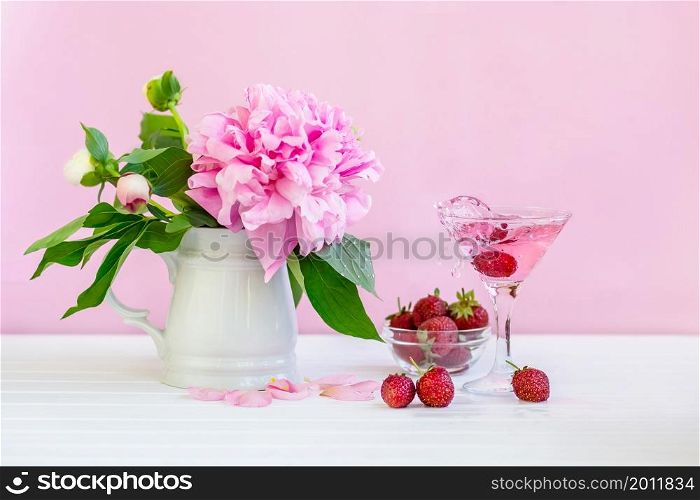 Pink peony next to glass of pink wine. pink background. Pink peony next to glass of pink wine.