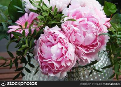 Pink peony summer flowers bouquet in a vase outdoors in a garden. Close up of pink summer flowers