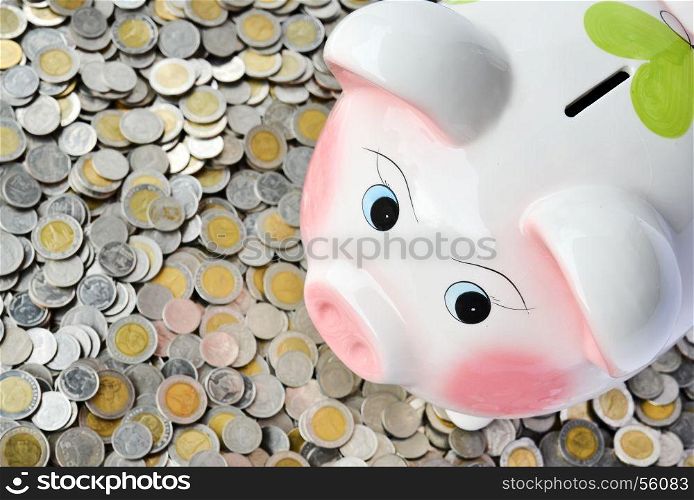 Pink piggy bank with many coins