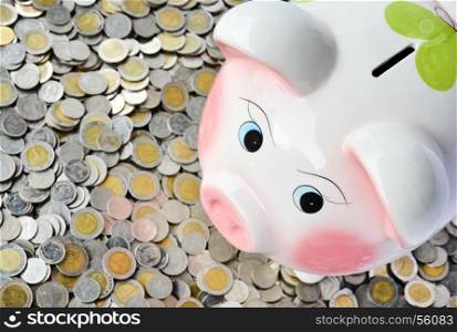Pink piggy bank with many coins