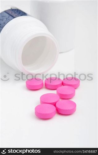 Pink Pills in White Bottle On White Background