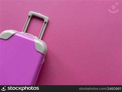 Pink plastic suitcase on pastel paper background.Travel concept holiday summer adventure trip. Flat lay with one simple thing. Stock photo.. Pink plastic suitcase on pastel paper background.Travel concept holiday summer adventure trip. Flat lay with one simple thing. Stock bright photo.
