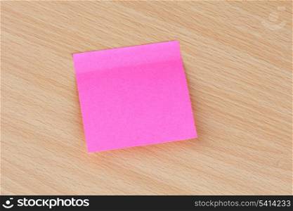 Pink Post-it stuck on a wooden surface