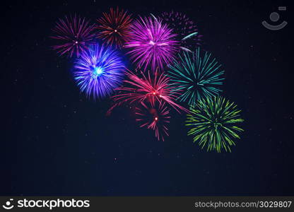 Pink purpe blue green fireworks over starry sky. Sparkling pink purpe blue green celebration fireworks over starry sky. Independence Day, 4th of July, New Year holidays salute background.