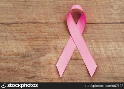 pink ribbon on wood. breast cancer awareness. concept healthcare and medicine