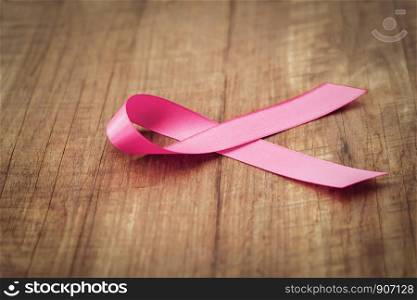 pink ribbon on wood. breast cancer awareness. concept healthcare and medicine