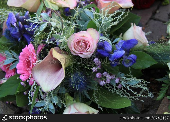 Pink roses and pink arums in a pink and blue floral arrangement
