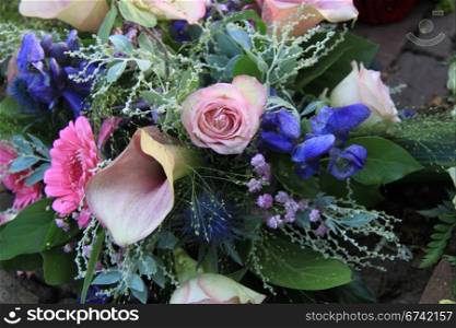 Pink roses and pink arums in a pink and blue floral arrangement