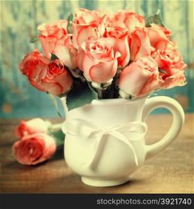 Pink roses in a pot on blue background
