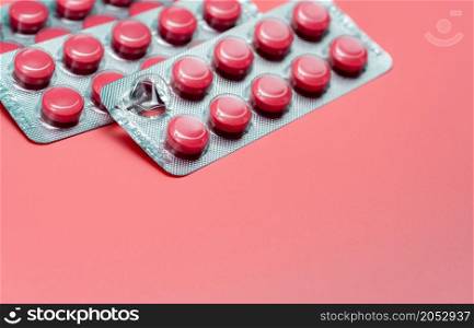 Pink round tablets pills in blister pack on pink background. Painkiller medicine. Take pill. Pharmacy product package. Pharmaceutical industry. Prescription drugs. Tablets pills for relieve pain.