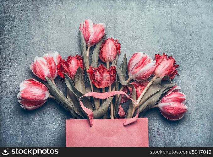 Pink shopping bag with beautiful tulips bunch, top view