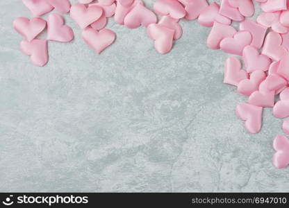 Pink silk hearts are on gray ctone surface. Background for Valentine&rsquo;s Day ore wedding composition with copy space