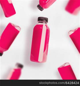 Pink smoothie or juice bottles pattern on white background, top view, flat lay. Branding copy space