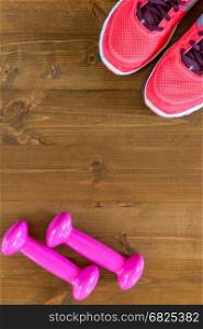 pink sneakers and a dumbbell in the corners of the frame on the wooden floor
