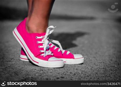 Pink sneakers on girl, young woman legs, outdoors in black and white