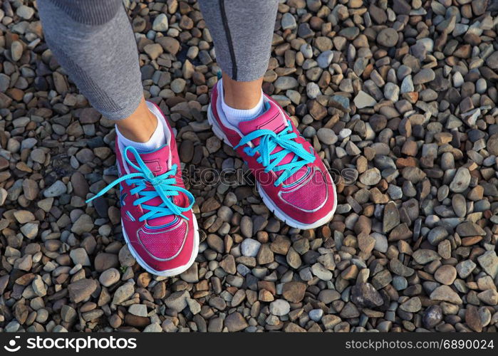 pink sports shoes of woman on gravel