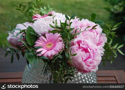 Pink summer flowers bouquet. Pink summer flowers bouquet in a vase outdoors in a garden