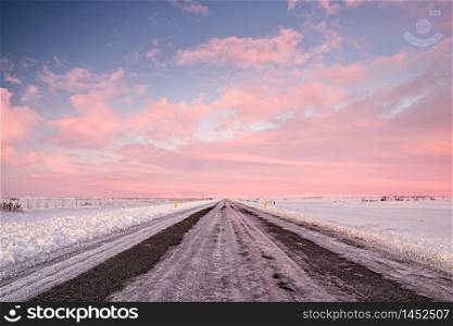Pink sunset in an iced road in Iceland. Sunset in Iceland