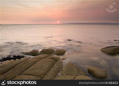 Pink sunset light on a coastal scene