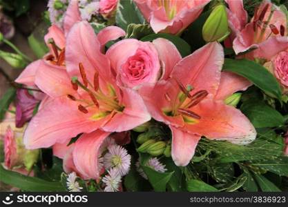 Pink tiger lilies and roses in a bridal arrangement
