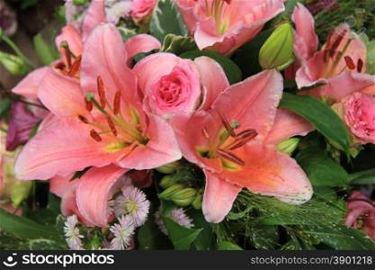 Pink tiger lilies and roses in a bridal arrangement