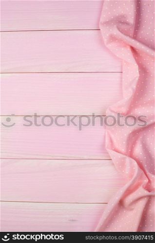 Pink towel over wooden kitchen table. View from above.