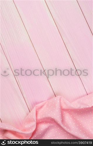 Pink towel over wooden kitchen table. View from above.