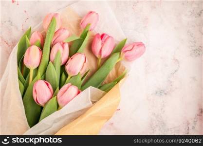 Pink tulip flowers bouquet on pale background. Flat lay, top view. Spring floral concept.