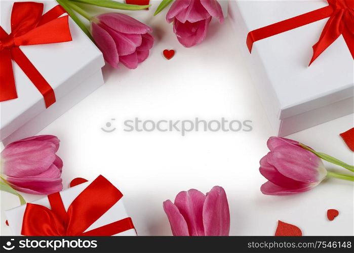 Pink tulip flowers gifts and red hearts composition on white background top view with copy space. Valentine&rsquo;s day, birthday, wedding, Mother&rsquo;s day concept. Copy space. Pink tulips hearts card