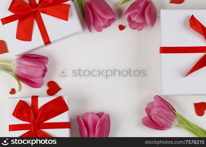 Pink tulip flowers gifts red hearts and gifts composition isolated on white background top view with copy space. Valentine&rsquo;s day, birthday, wedding, Mother&rsquo;s day concept. Copy space. Pink tulips hearts gifts card