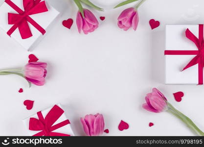 Pink tulip flowers gifts red hearts and gifts composition on white background top view with copy space. Valentine’s day, birthday, wedding, Mother’s day concept. Copy space. Pink tulips hearts gifts card