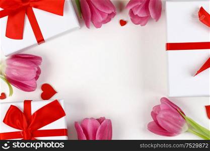 Pink tulips gifts and hearts border frame with copy space on white background Valentines day concept. Valentines day background