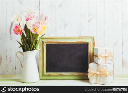 Pink tulips in jug and green wooden chalkboard. Teacher&amp;#39;s day concept