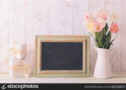 Pink tulips in jug and green wooden chalkboard. Teacher&amp;#39;s day concept