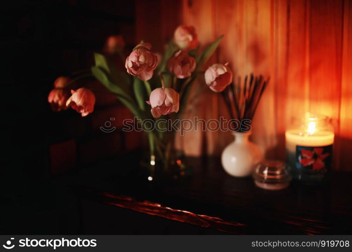 Pink tulips on a pink background. A bouquet of tulips in the interior of the bedroom. Blur effect. Selective focus, close-up. Spring interior. Pink tulips on a pink background. A bouquet of tulips in the interior of the bedroom. Blur effect. Selective focus, close-up. Spring interior.