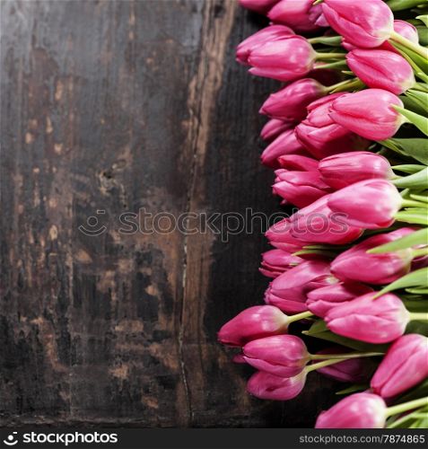 Pink tulips on Old grunge wooden background