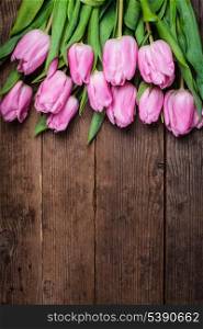 Pink tulips over shabby white wooden background