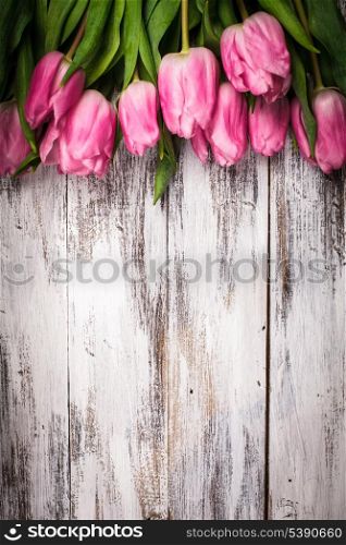 Pink tulips over shabby white wooden table