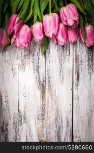 Pink tulips over shabby white wooden table