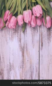 Pink tulips over shabby white wooden table, vintage retro style