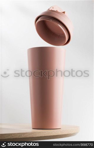 Pink tumbler or Thermos on wooden table