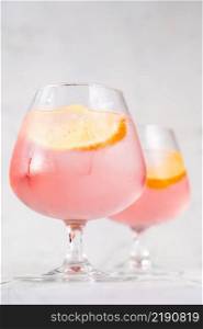 Pink vodka lemonade cocktail garnished with lemon wedge