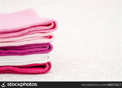 Pink, white and purple pair of child socks on white background with copyspace