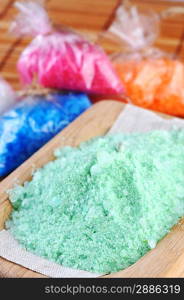 Pink, white, blue, green and orange salt for bath on straw napkin