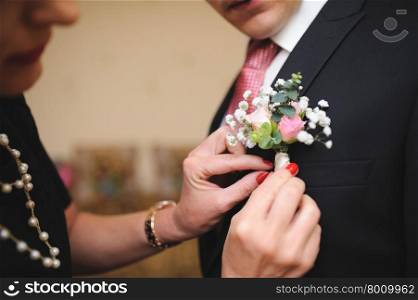 Pinning a Boutonniere for groom on his wedding