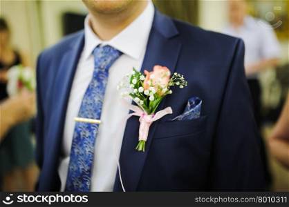 Pinning a Boutonniere for groom on wedding day
