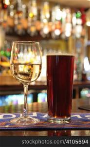 pint of beer and glass of white wine on bar in a pub